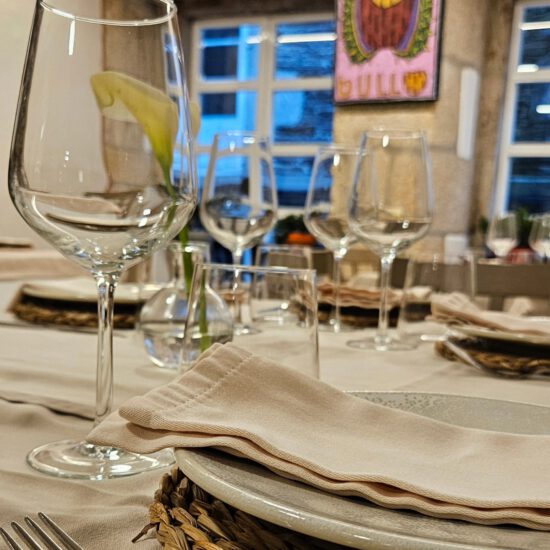 Mesa con copas de vino y platos en restaurante elegante con decoración moderna.