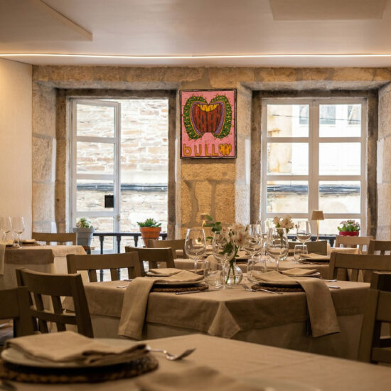 Interior de un comedor rústico con mesas dispuestas y decoración acogedora