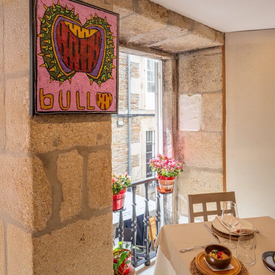 Mesa en restaurante con pintura colorida y vista al balcón con flores